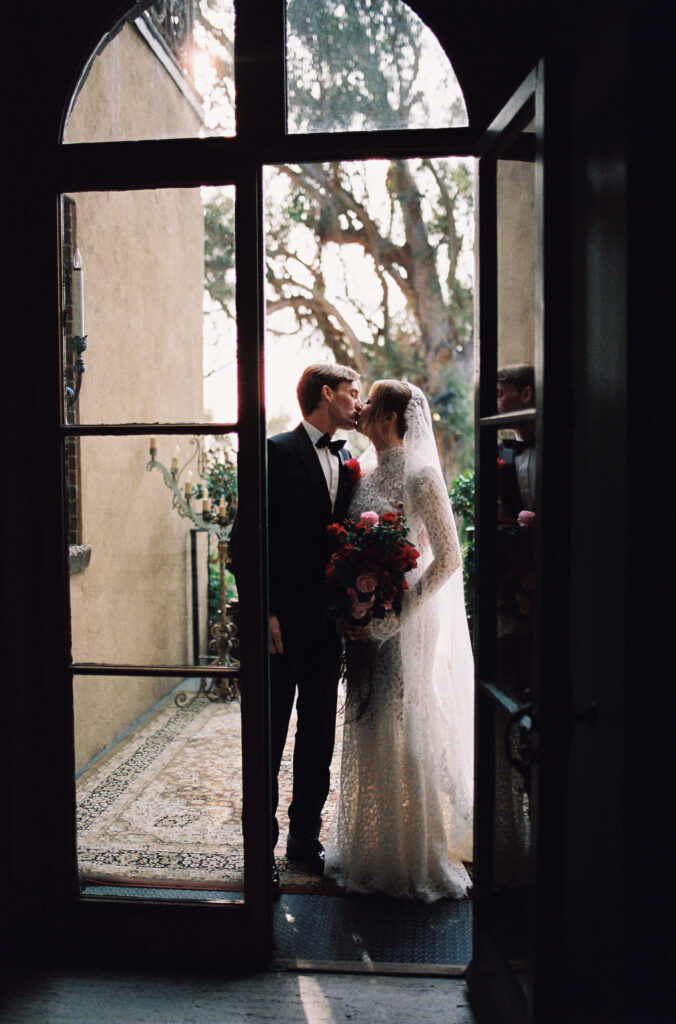 A couple kissing on a terrace, sharing a warm and intimate moment.